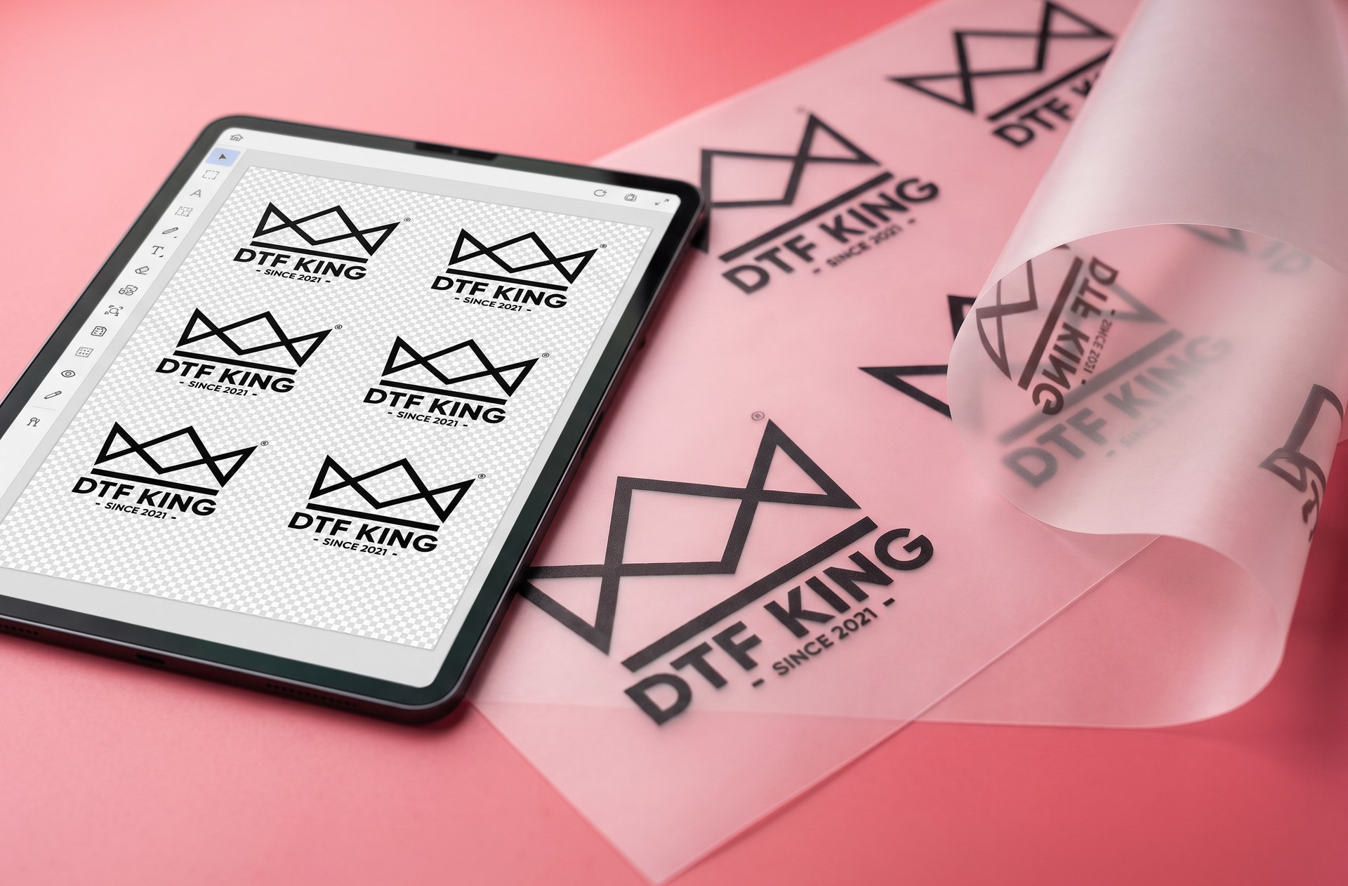Tablet with the DTF Designer and a gang sheet open, next to printed DTF transfer film