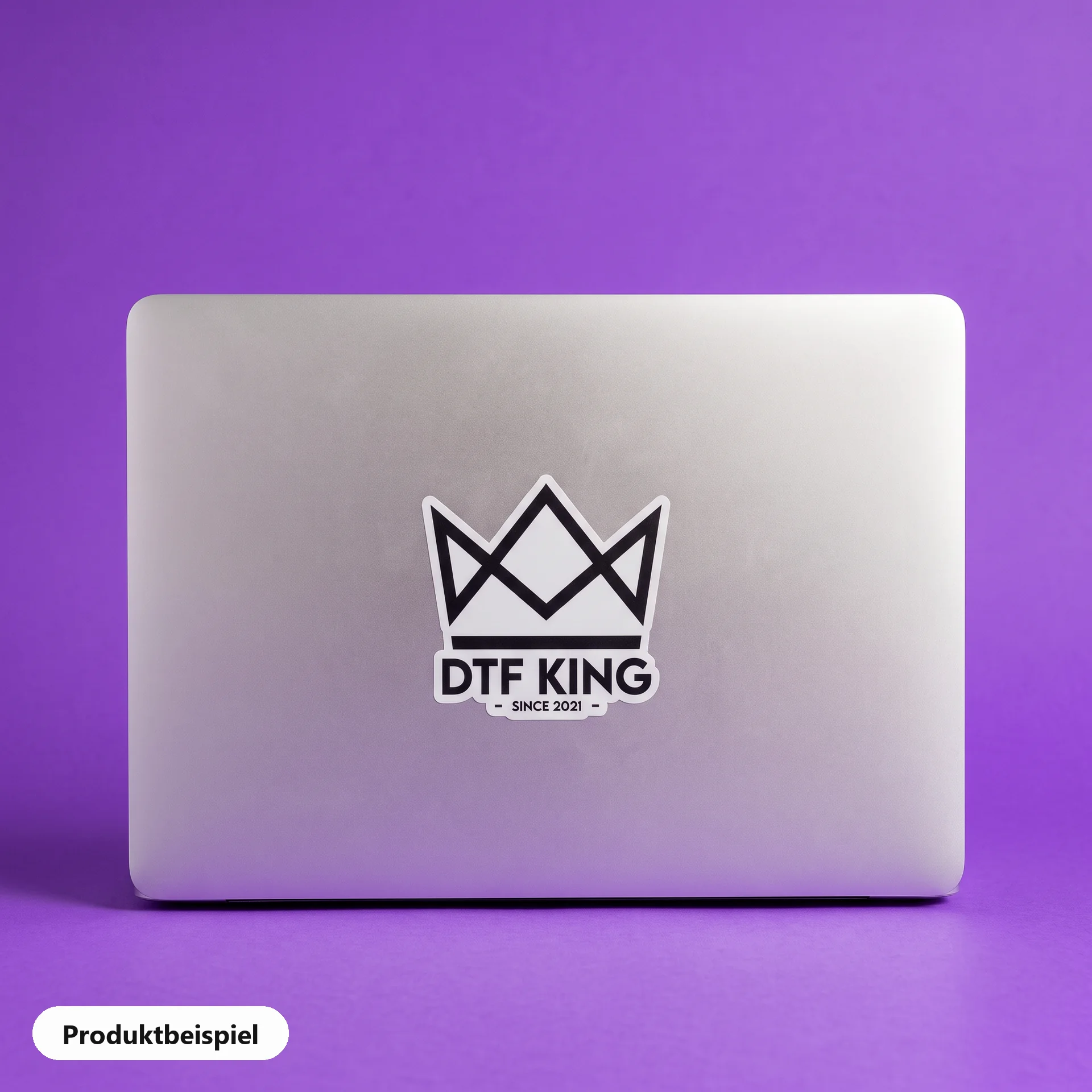 Contour-cut vinyl sticker on white film, matt laminated, with the DTF KING logo on a laptop lid