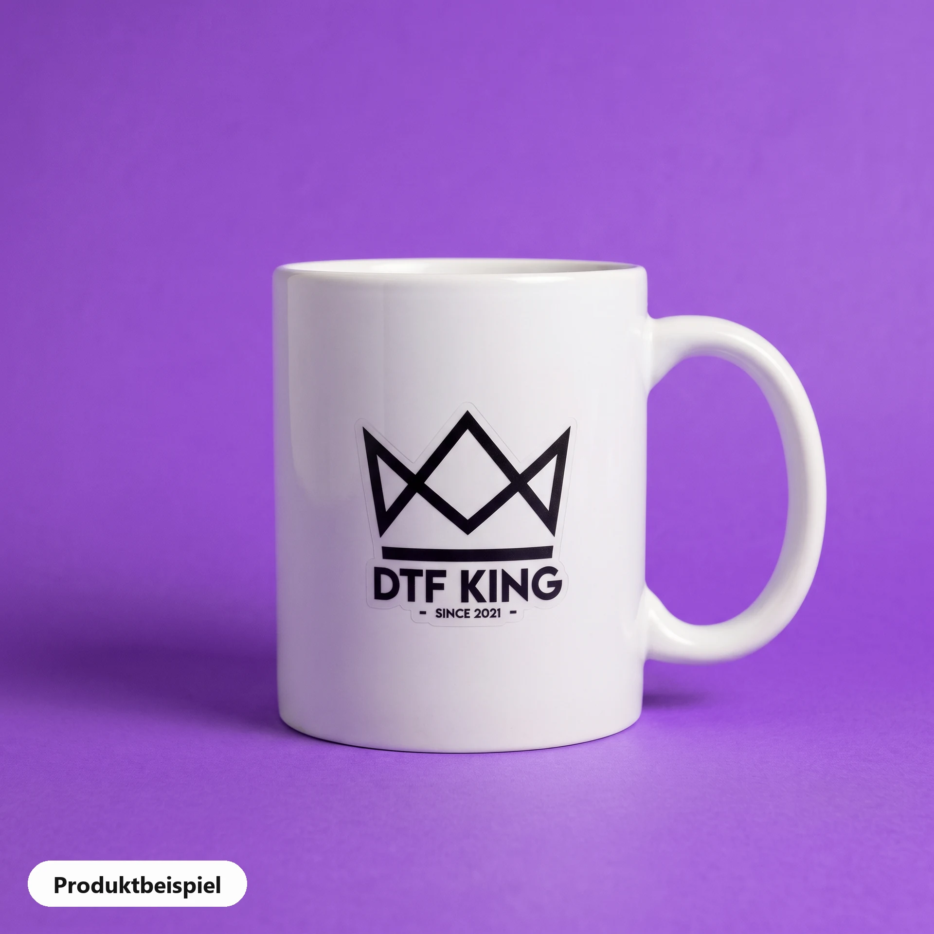 Contour-cut vinyl sticker on clear film, matt laminated, with the DTF KING logo on a white mug