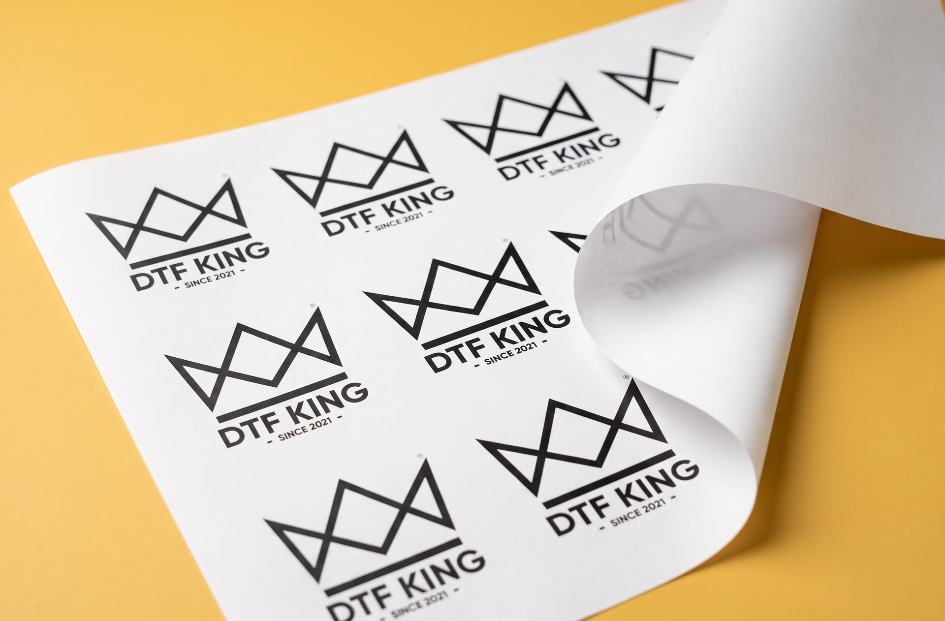 Sublimation paper with printed DTF-King logos on a yellow background