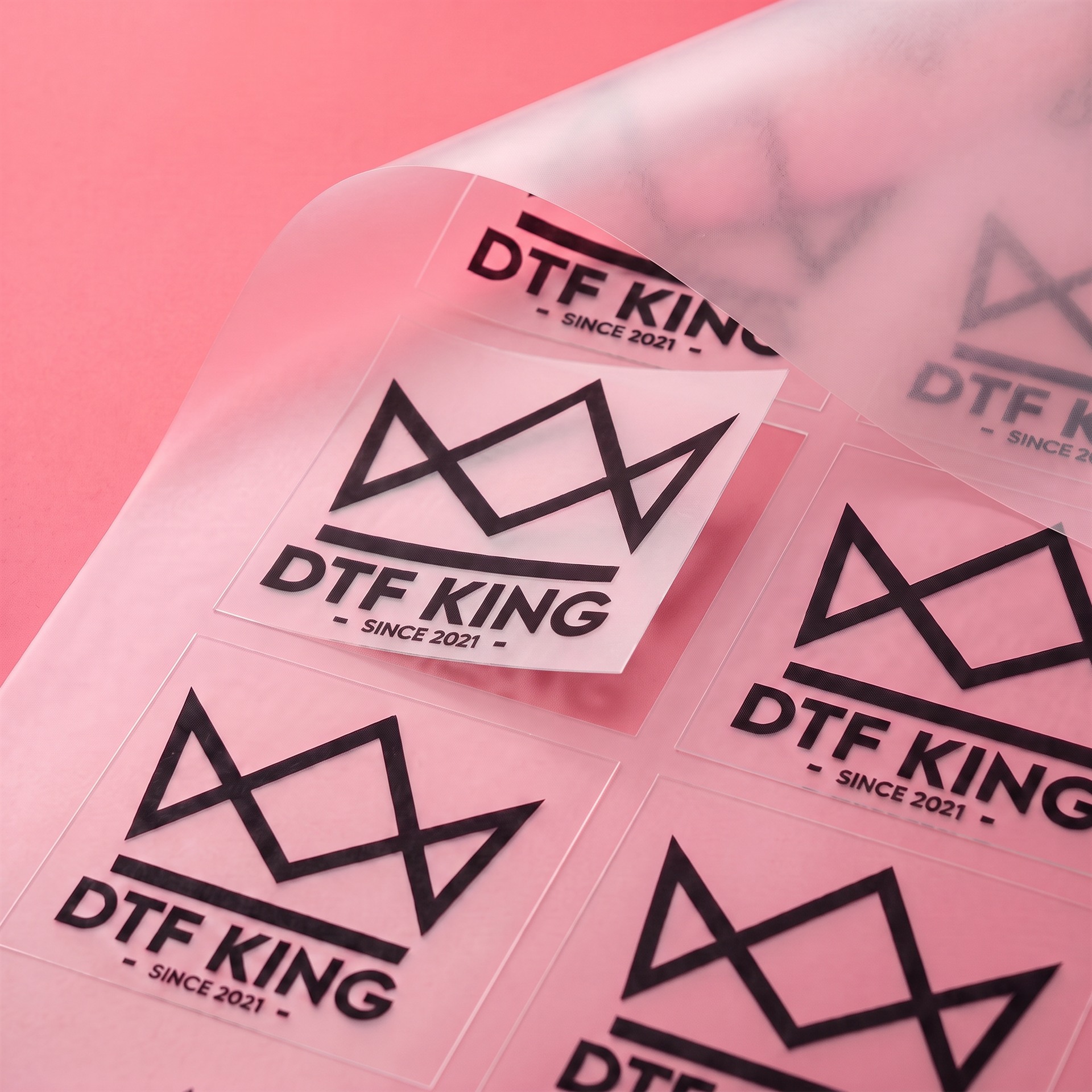 CUT DTF-Transfer, rechteckig zugeschnittene Motive mit DTF-King Logo vor pinkem Hintergrund