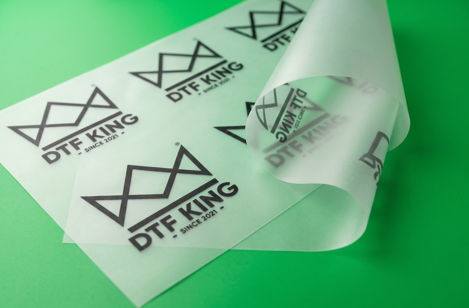 Printed Blockout DTF transfer film with DTF-King logos on a green background