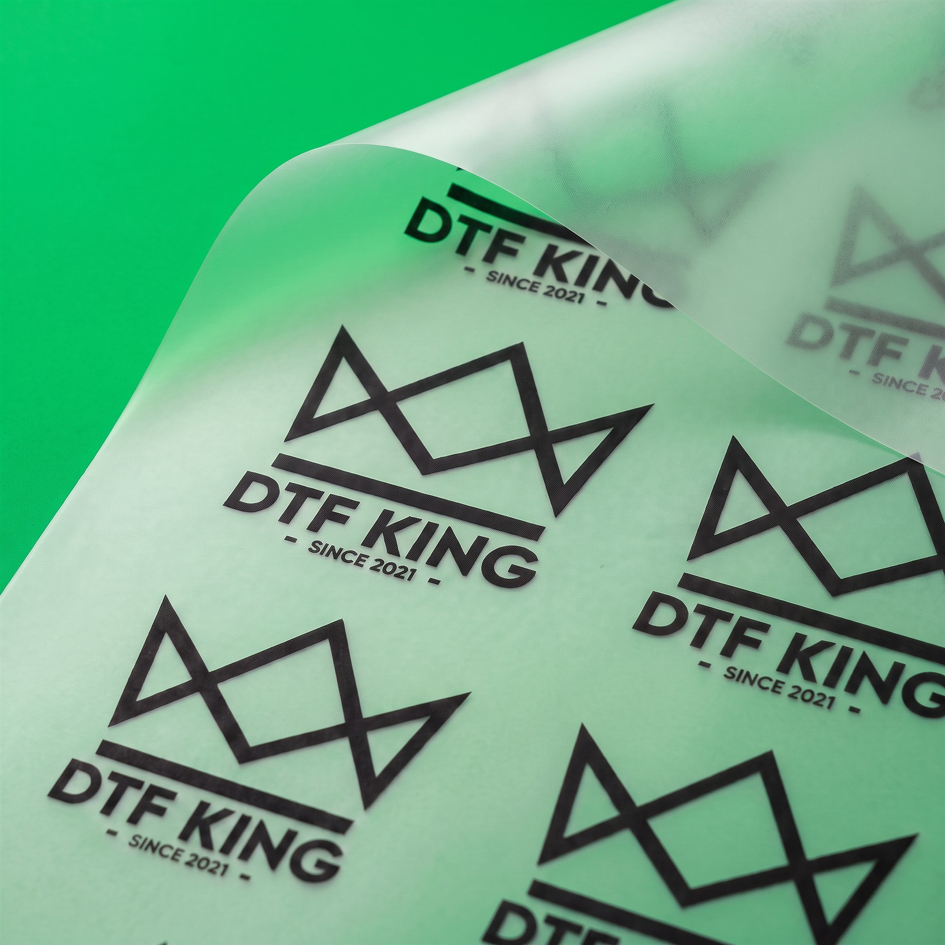 Blockout DTF-Transfer Meterware von der Rolle mit DTF-King Logo vor grünem Hintergrund