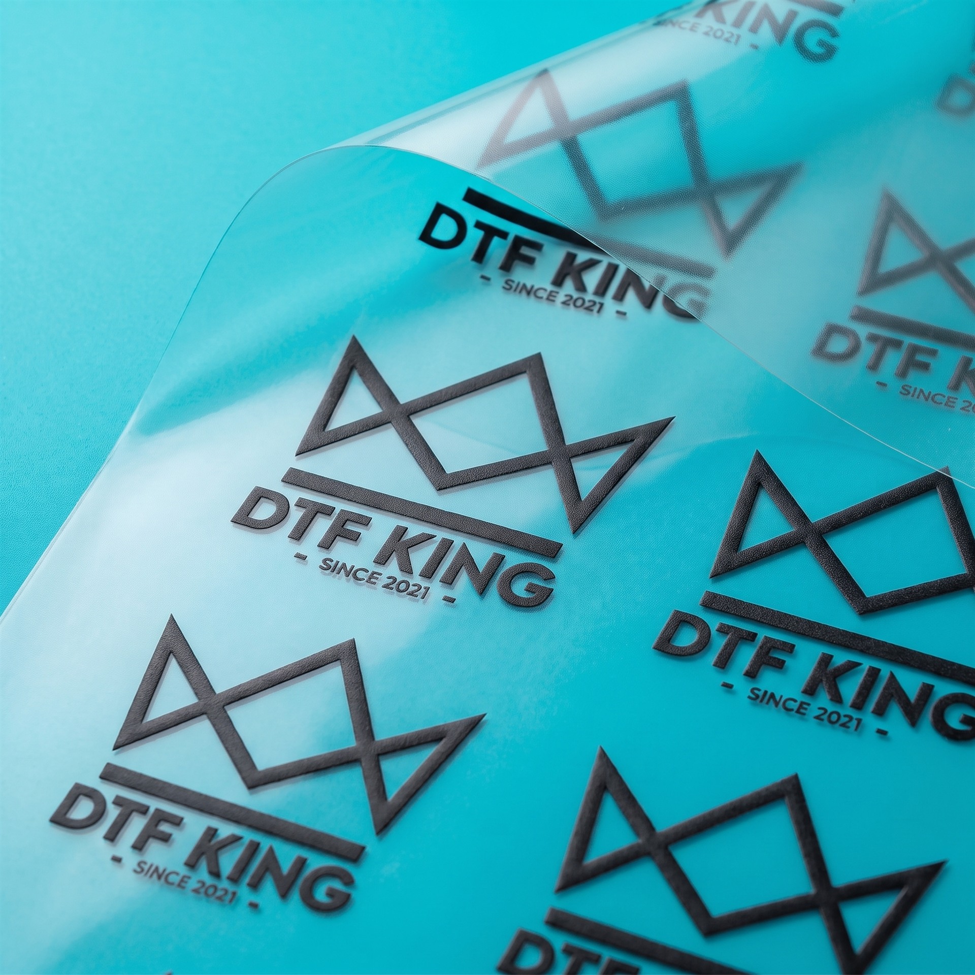 UV DTF Transfer matt von der Rolle mit DTF-King Logo vor türkisem Hintergrund