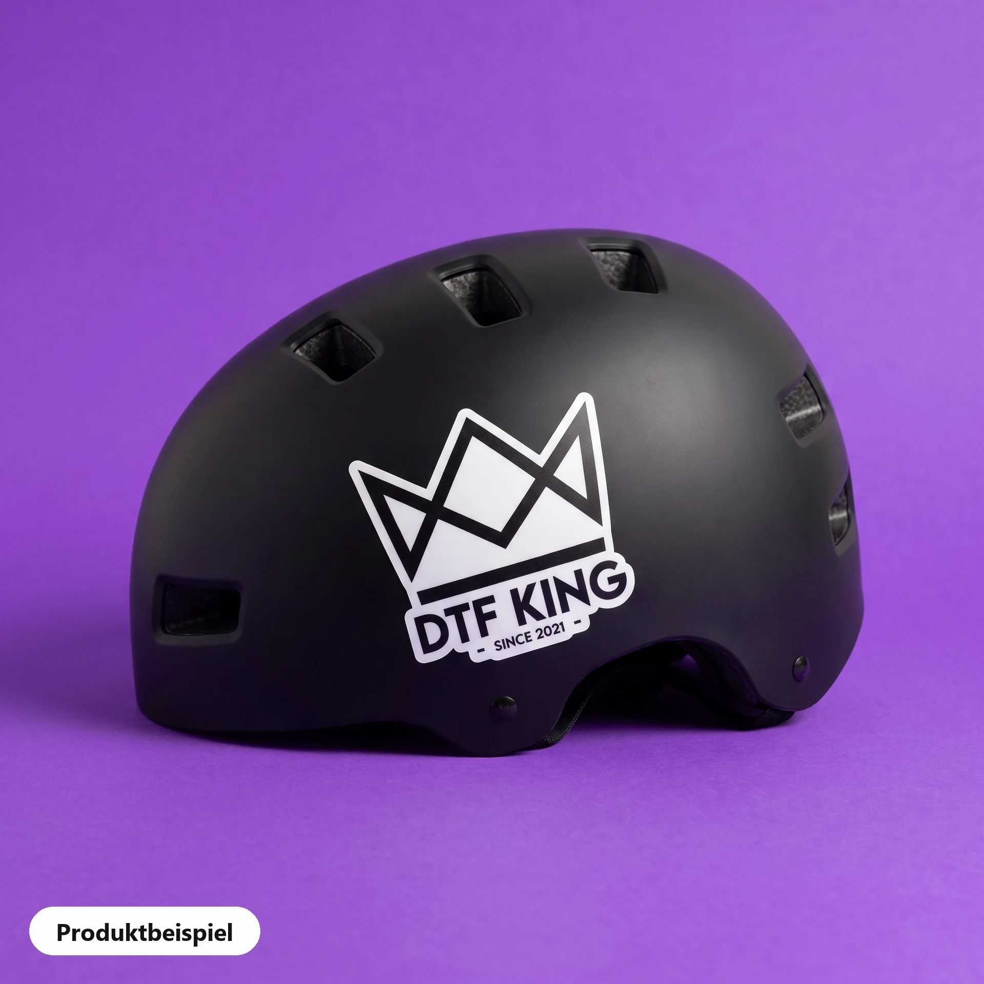 Contour-cut vinyl sticker on white film, matt laminated, with the DTF KING logo on a bicycle helmet