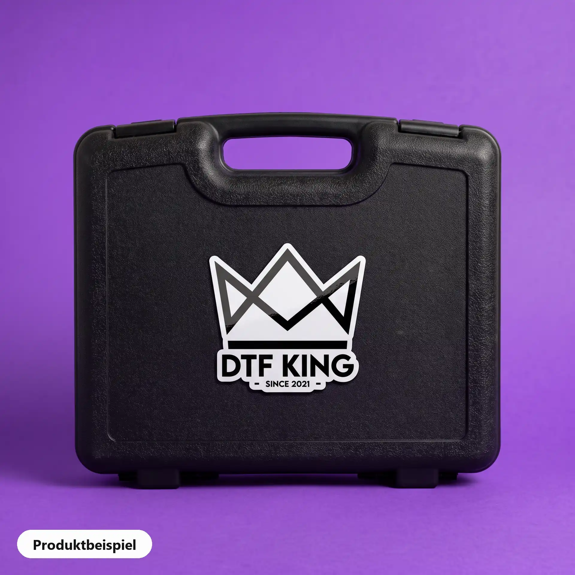 Konturgeschnittener Vinyl-Sticker auf weißer Folie, glänzend laminiert, mit dem DTF-KING-Logo auf einem Werkzeugkoffer