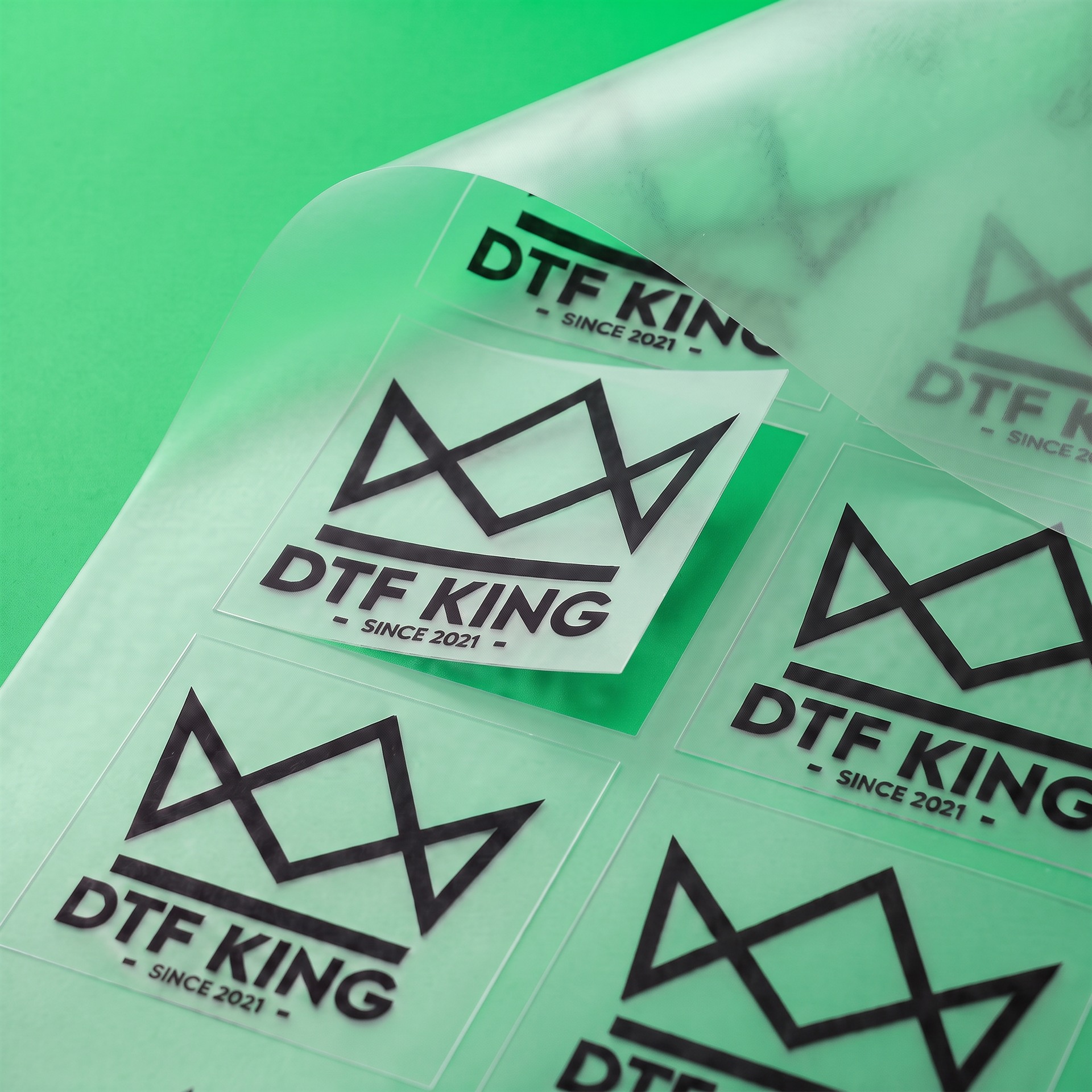 CUT Blockout DTF-Transfer, rechteckig zugeschnittene Motive mit DTF-King Logo vor grünem Hintergrund