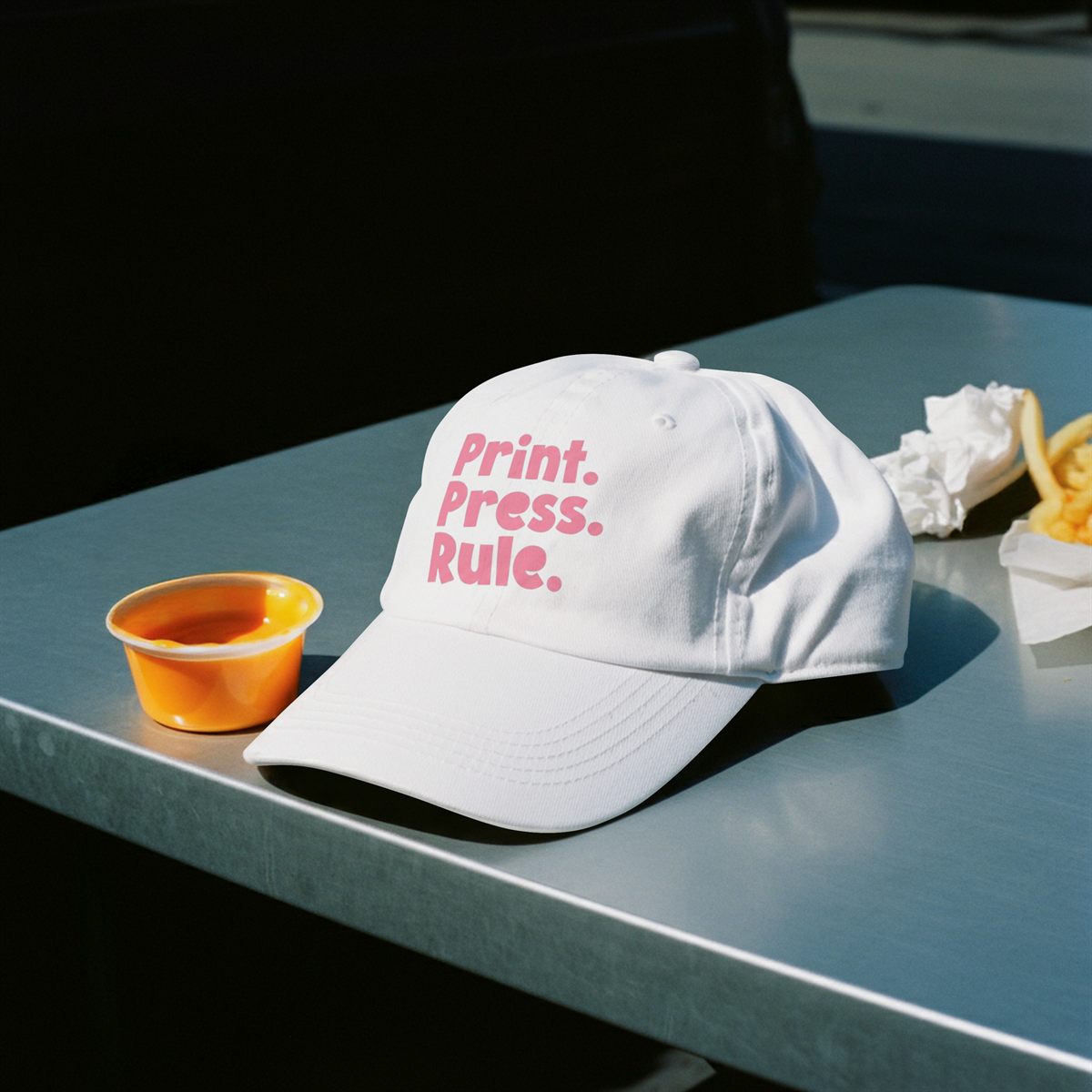 White cap printed with a DTF transfer, pink lettering on the front