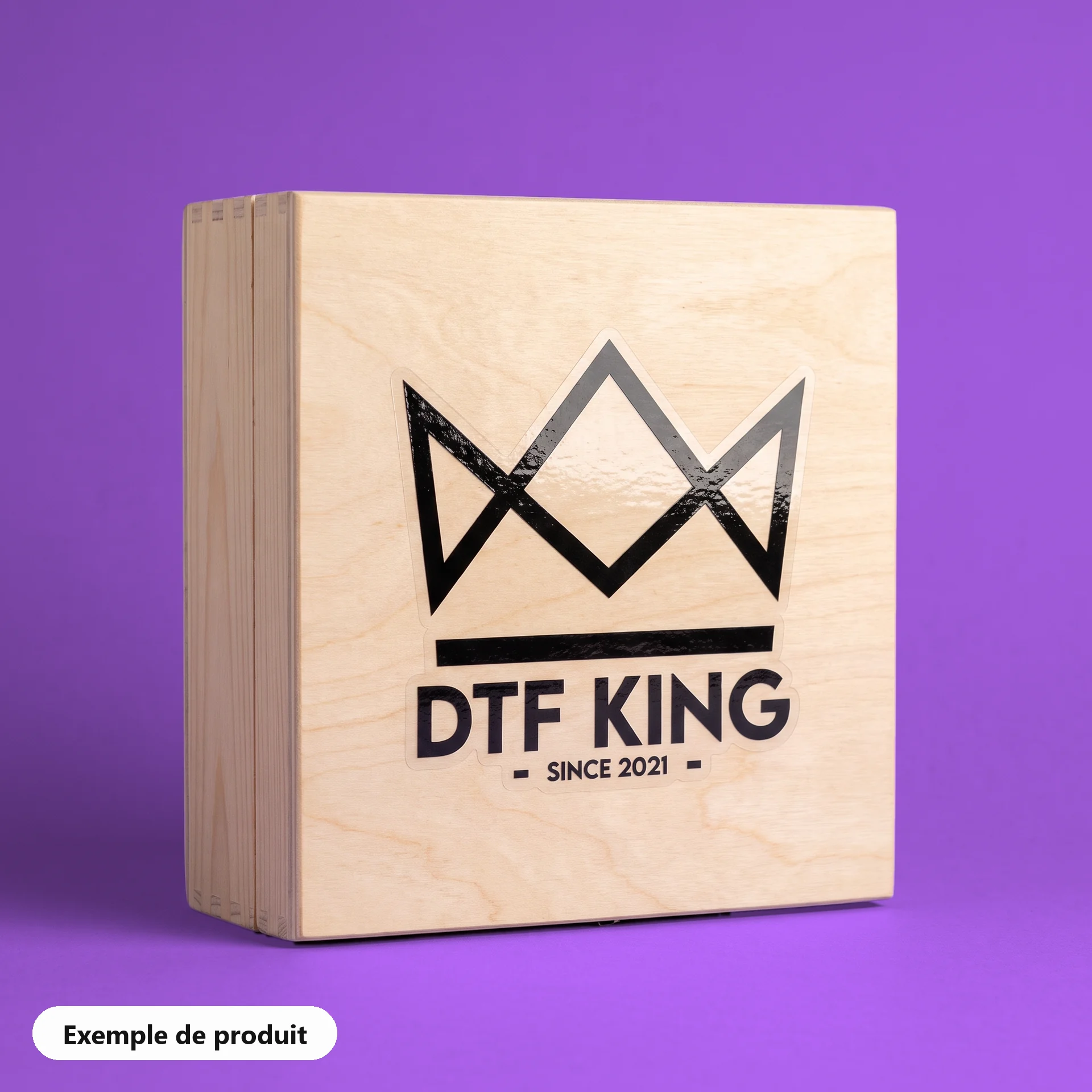 Autocollant vinyle découpé à la forme sur film transparent, pelliculage brillant, avec le logo DTF KING sur une caisse en bois