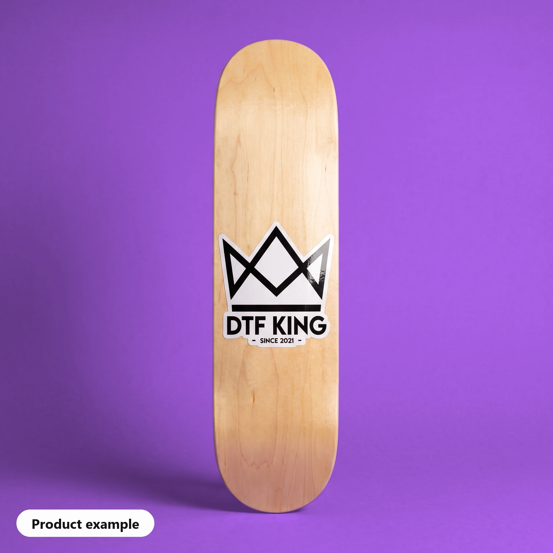 Contour-cut vinyl sticker on white film, gloss laminated, with the DTF KING logo on a skateboard deck