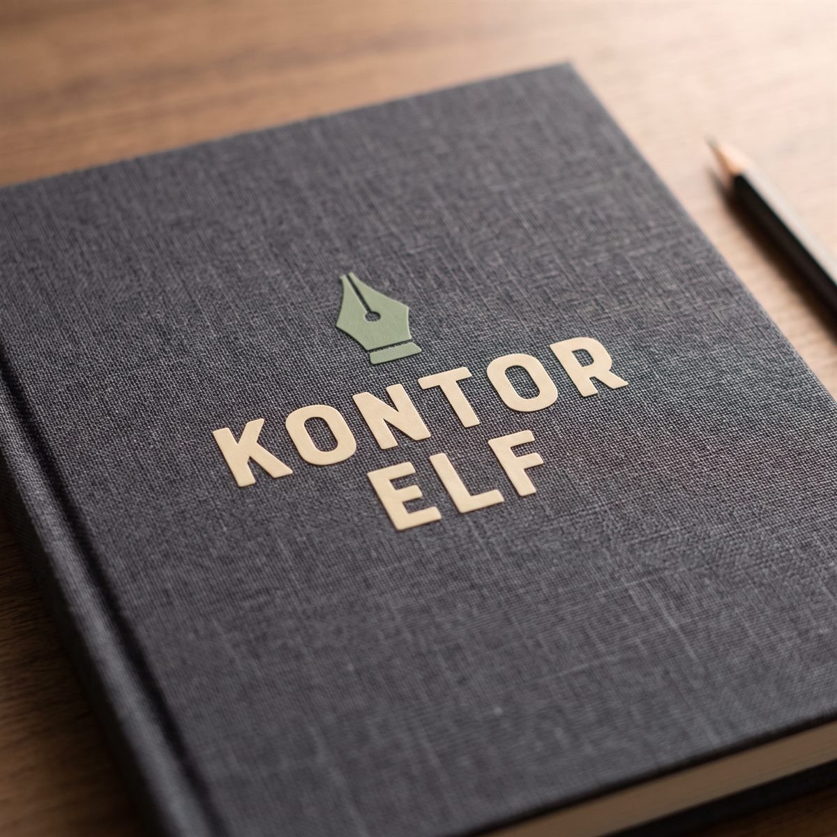 Dark grey notebook with a matt UV DTF rub-on sticker, cream lettering