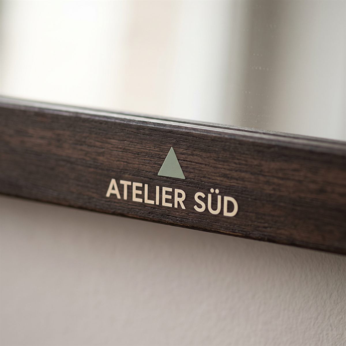 Dark wooden picture frame with a matt UV DTF rub-on sticker, cream studio name