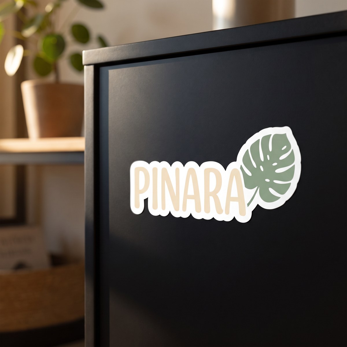 Konturgeschnittener Vinyl-Sticker auf weißer Folie mit dem Logo einer Beispielfirma auf einer dunkel lackierten Möbelfront