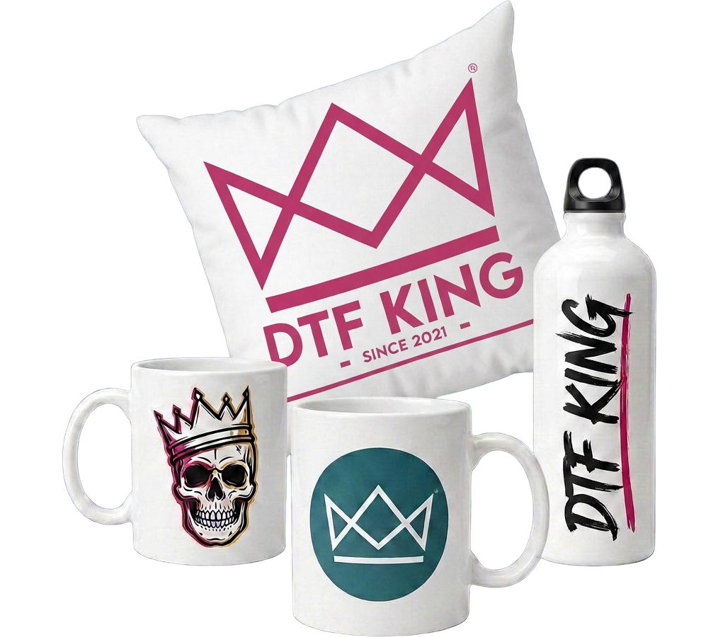 Weißes Kissen mit dem DTF-King-Logo in Beere, schräg gestellt, davor zwei Tassen mit Totenkopf- und Kronenmotiv sowie eine Trinkflasche mit DTF-King-Schriftzug, alle im Sublimationsdruck